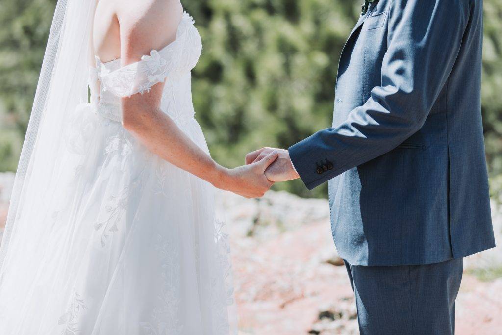 Bride and groom holding hands in Denver Colorado Wedding Photographer and videographer session.