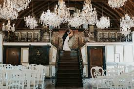 Inside the Chandelier Room at Lionsgate Event Center with a bride and groom kissing at the top of the stairs.