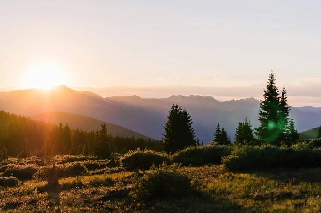 sun peaking over the mountains in Colorado