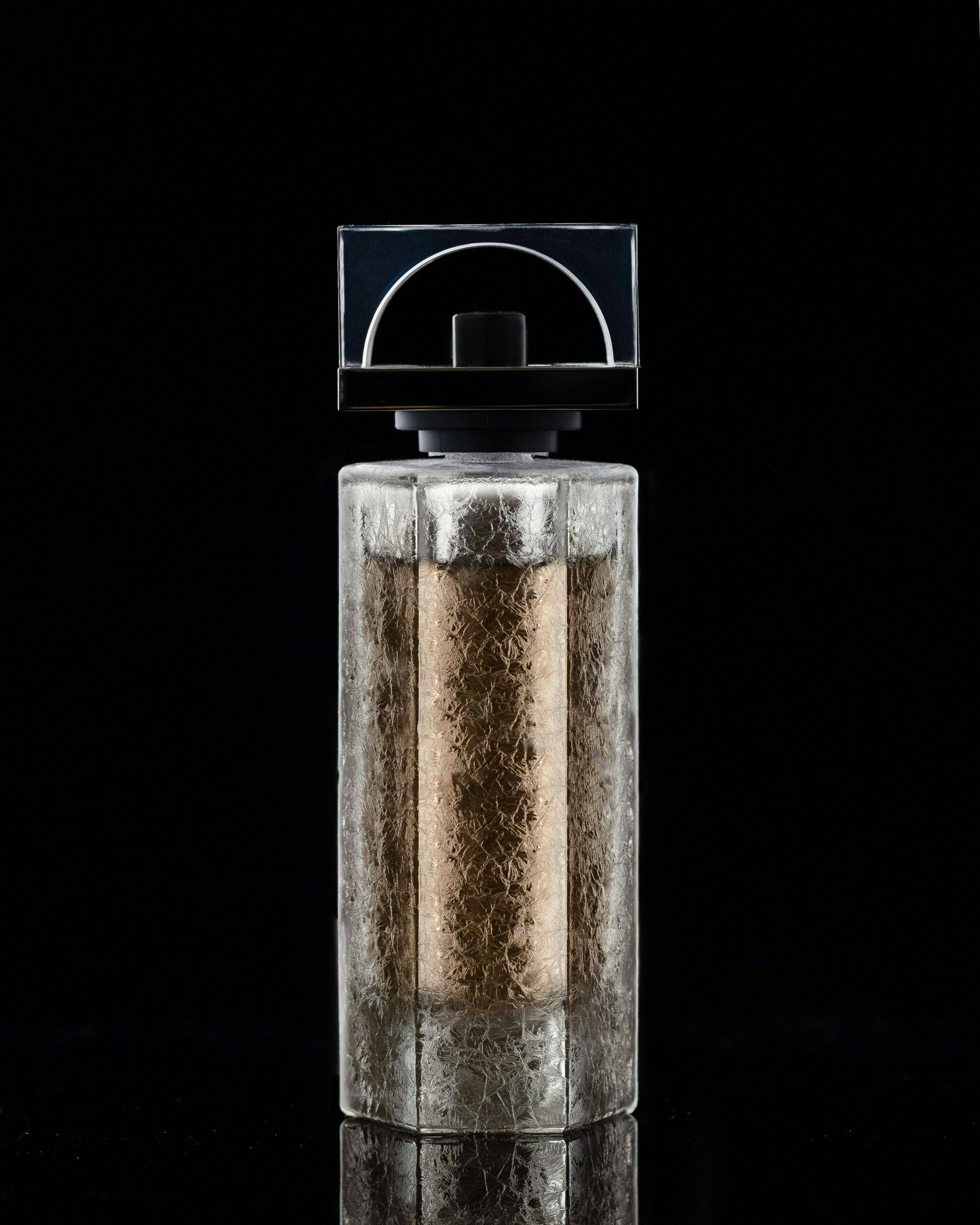 a bottle of perfume on a black backdrop