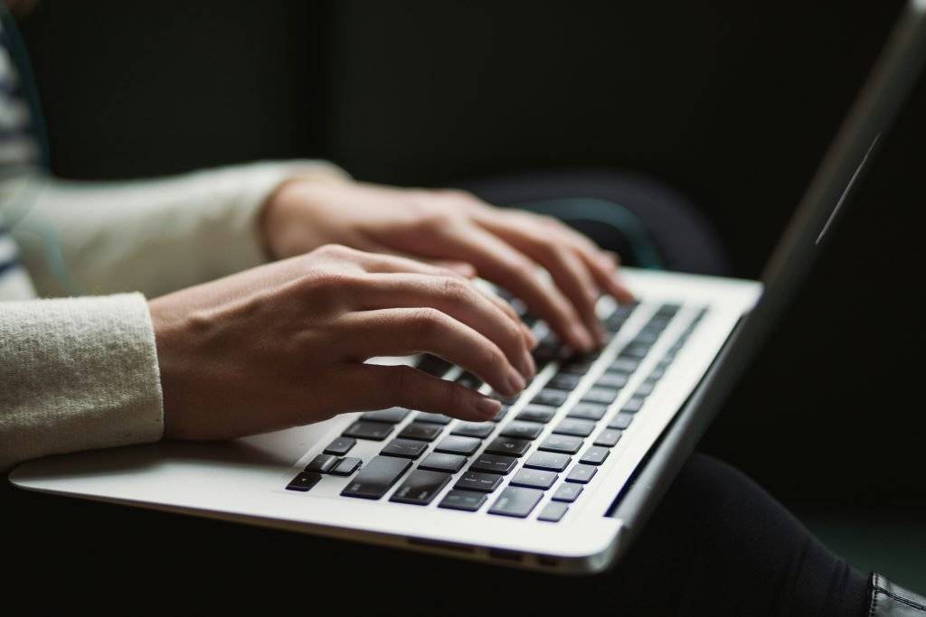 Someone typing on a MacBook computer