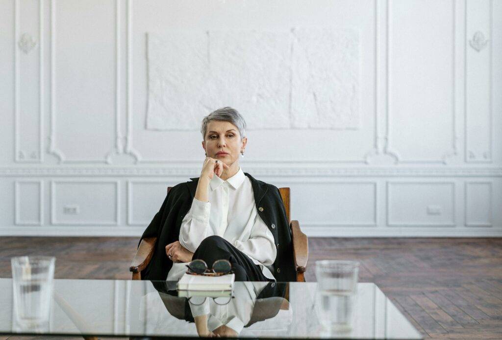 a woman sitting at a glass table thinking