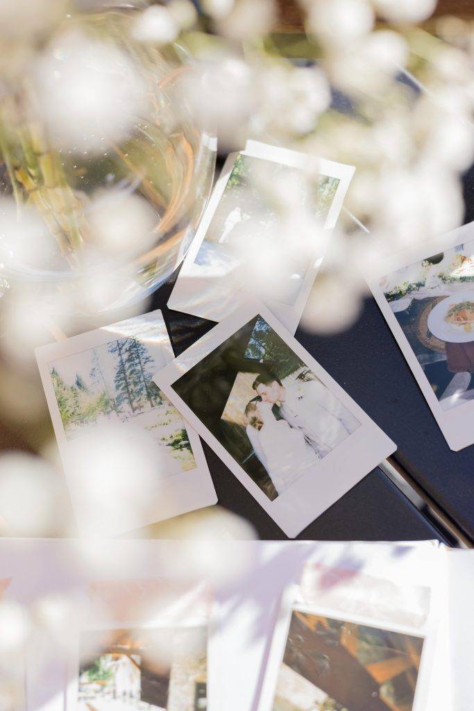 wedding polaroid images on a table with baby breathe flowers in the foreground.