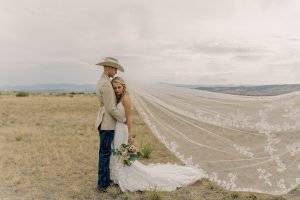 bride and groom embracing one another in a field in Colorado.
