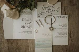 wedding details with wedding invitations and jewelry.