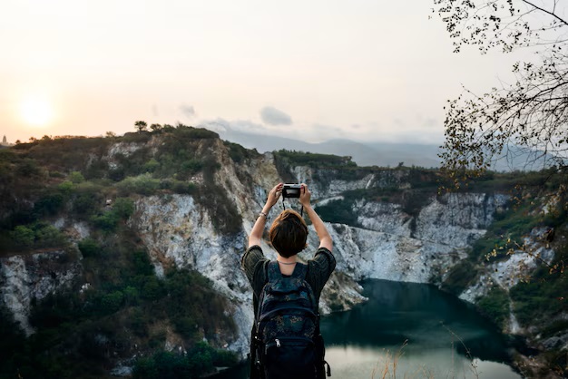 A woman holding a camera up to take travel photography pictures.